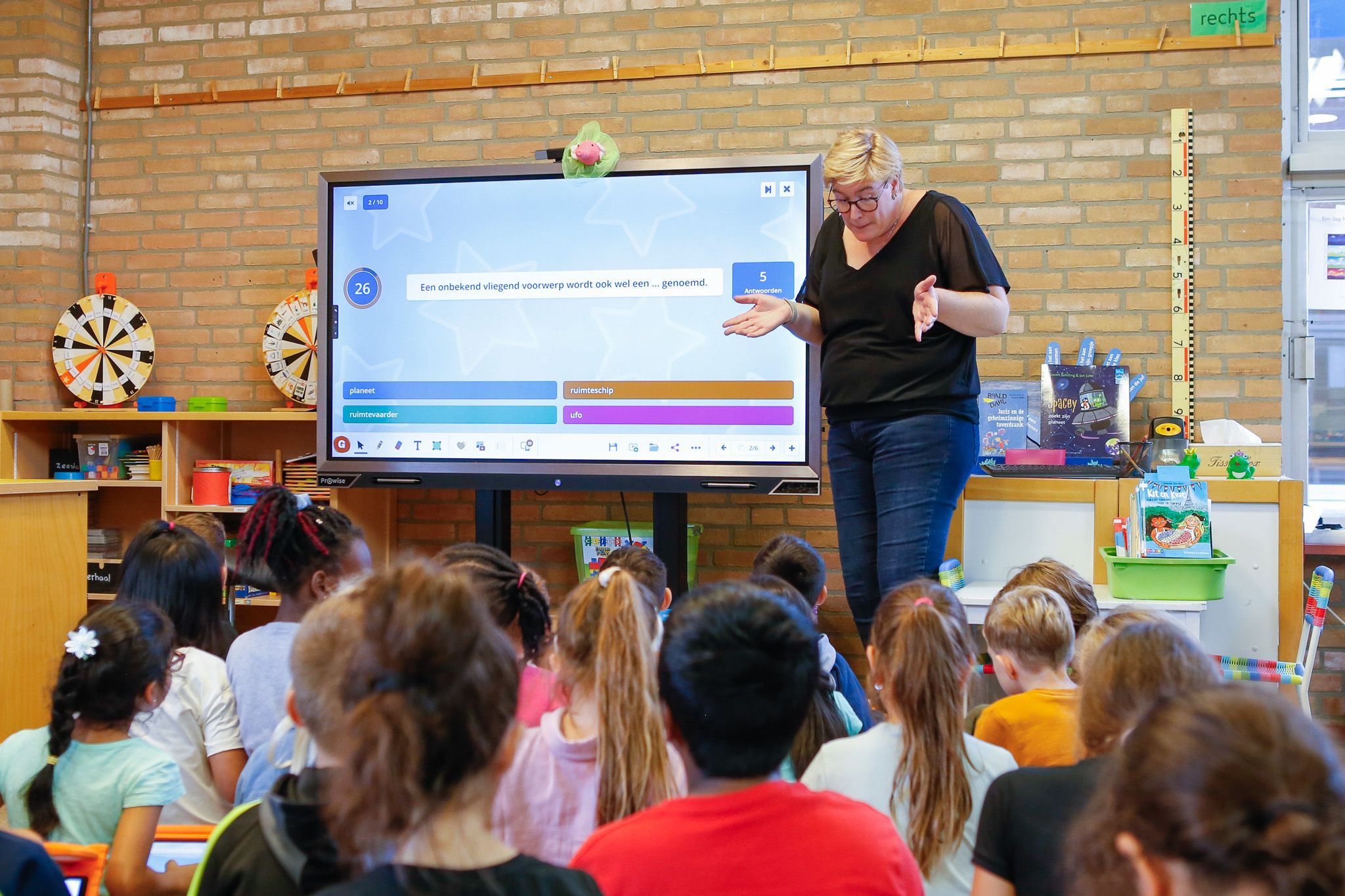 Leerkracht presenteer Klassenquiz aan leerlingen op het digibord