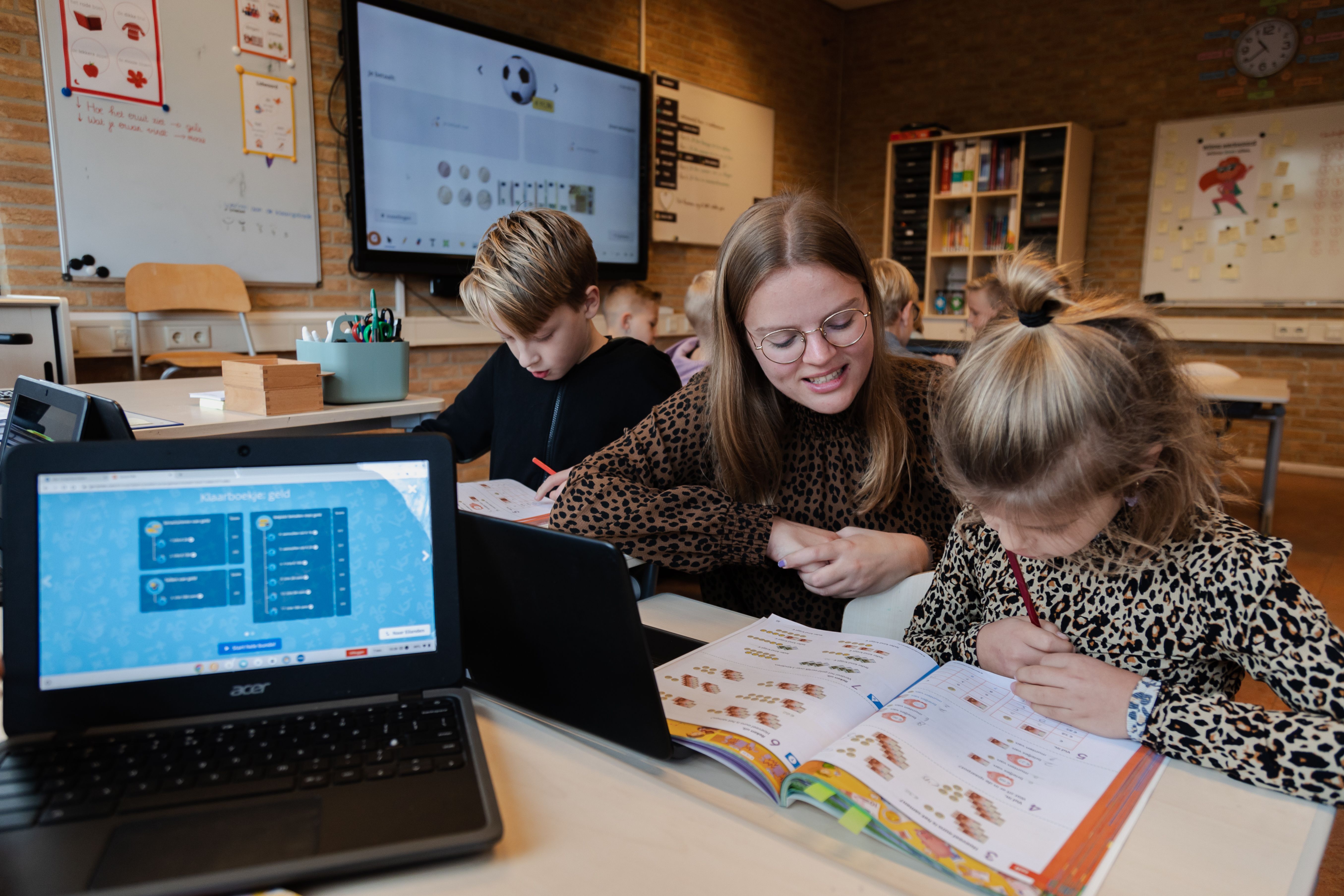 Leerkracht helpt leerling met rekenen