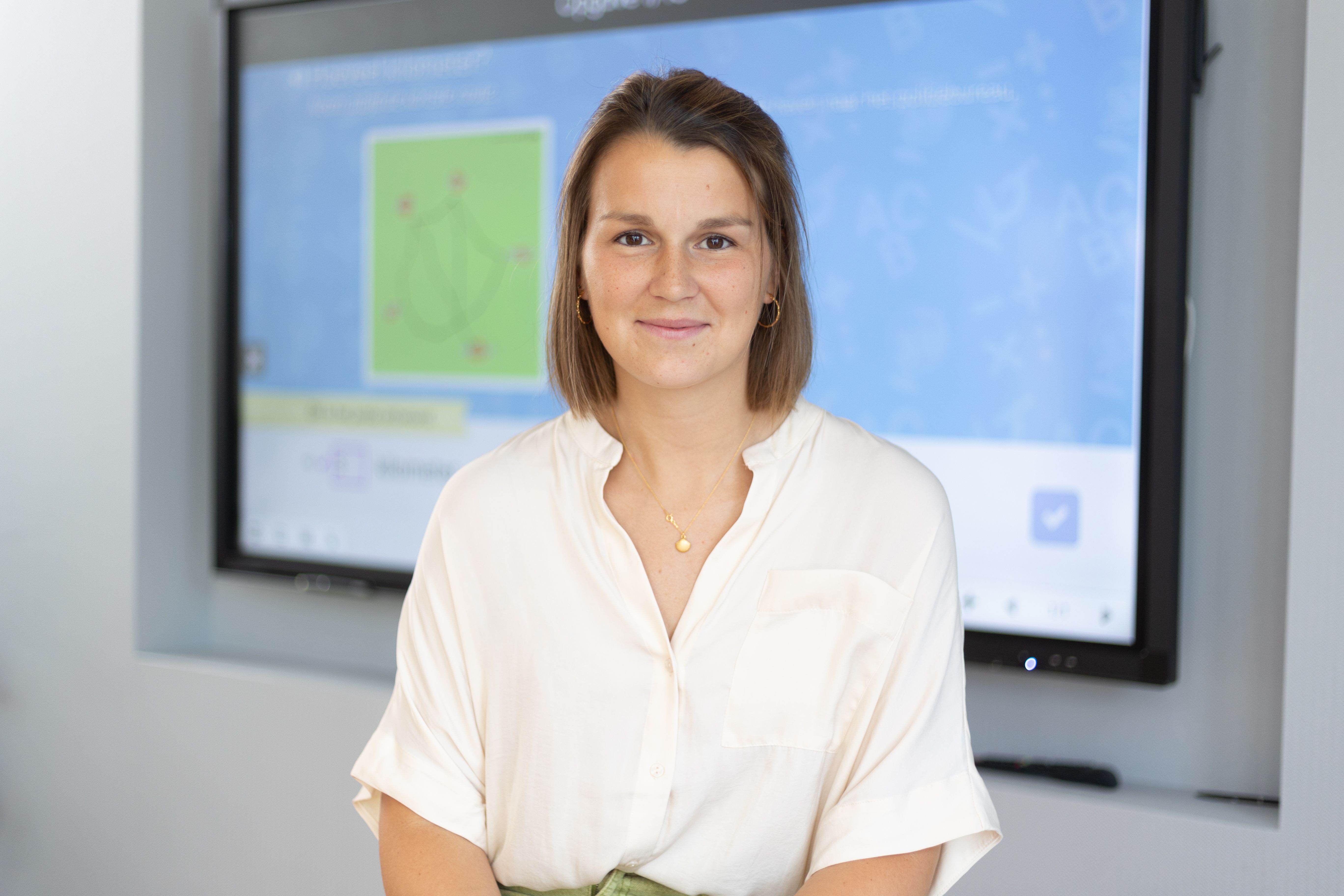 teacher in front of digital whiteboard